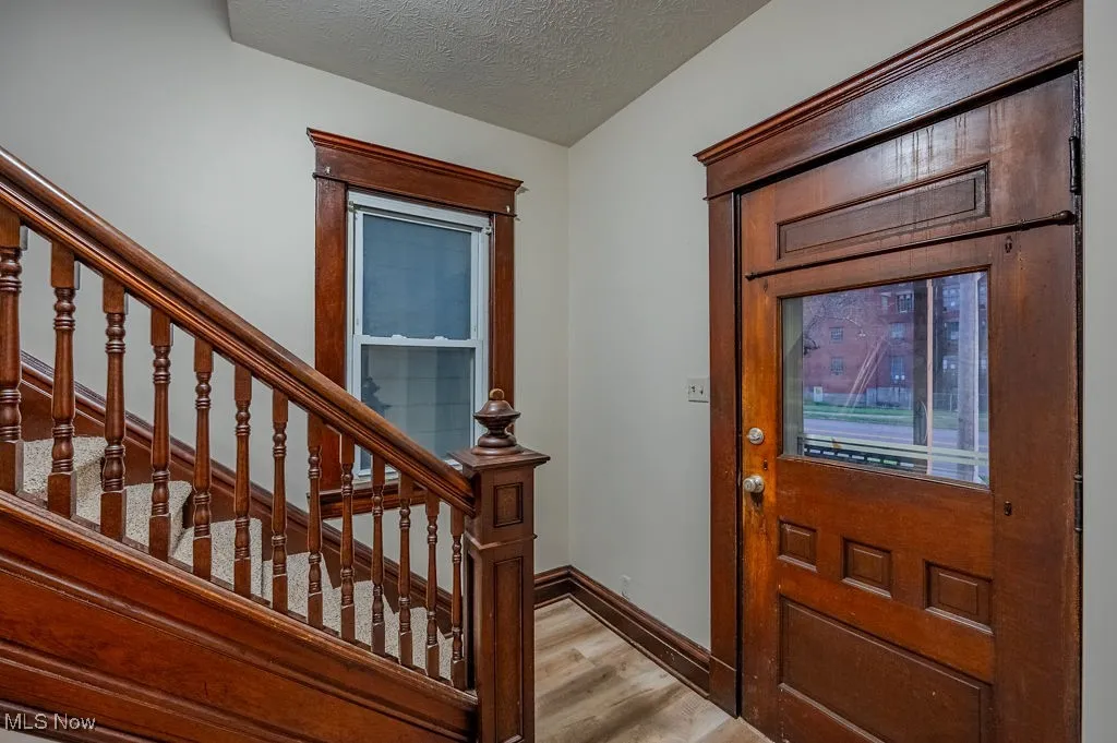 Entryway with a textured ceiling and light wood-type flooring