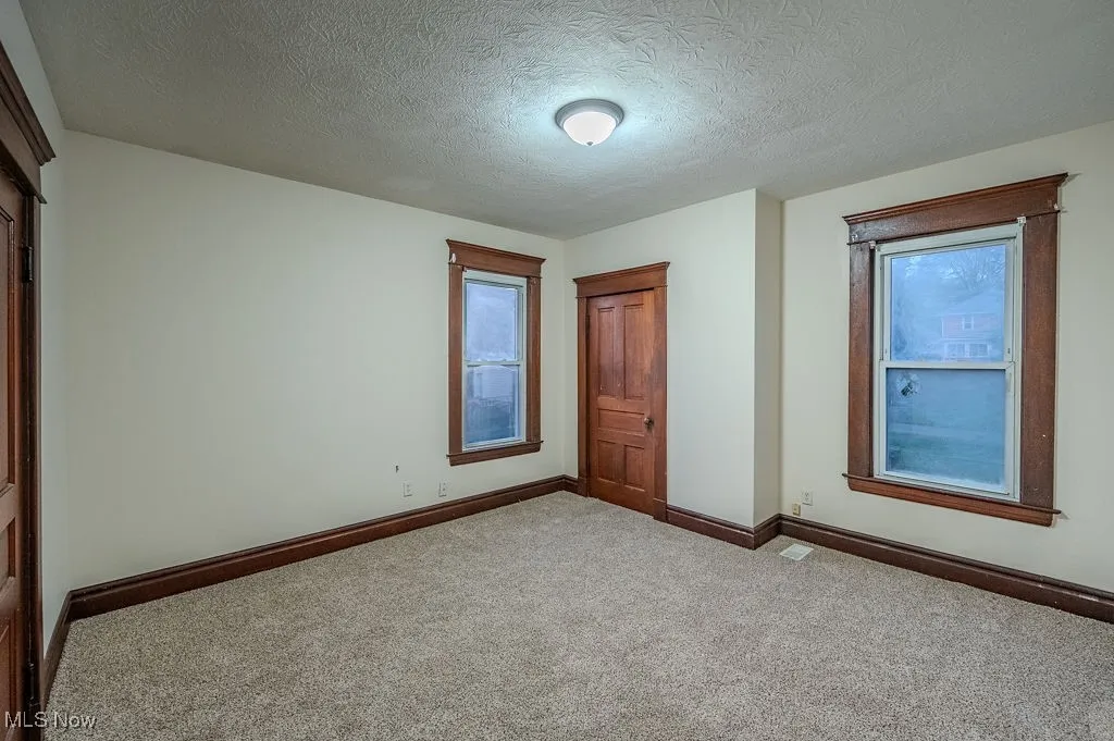 Unfurnished bedroom with carpet floors and a textured ceiling