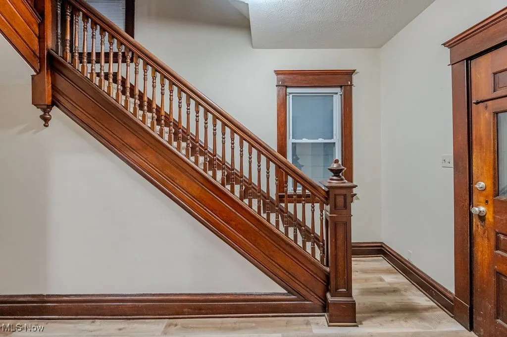 Stairs featuring hardwood / wood-style floors and a textured ceiling