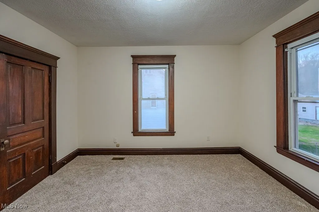 Carpeted empty room featuring a textured ceiling