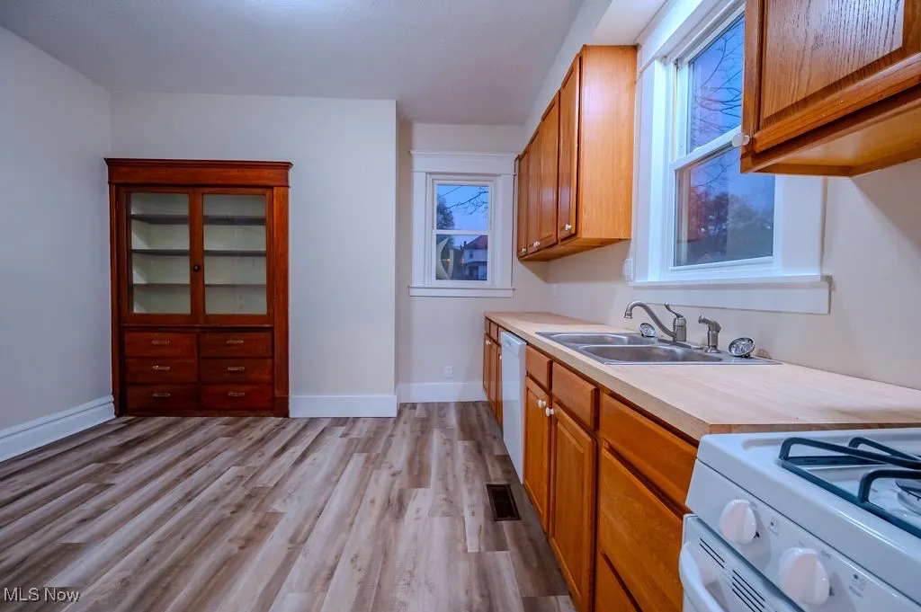 Kitchen featuring white appliances, sink, and light hardwood / wood-style flooring