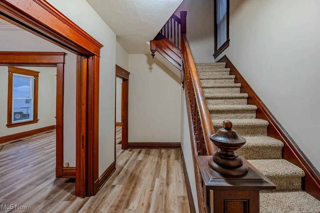 Staircase with wood-type flooring and a textured ceiling