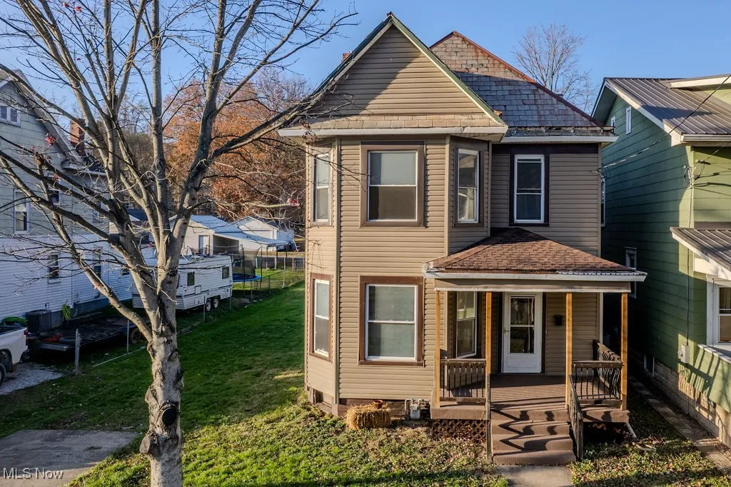 View of front property with covered porch and a front yard
