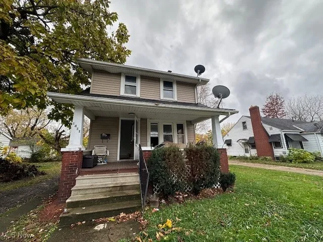 View of front of property featuring covered porch and a front yard
