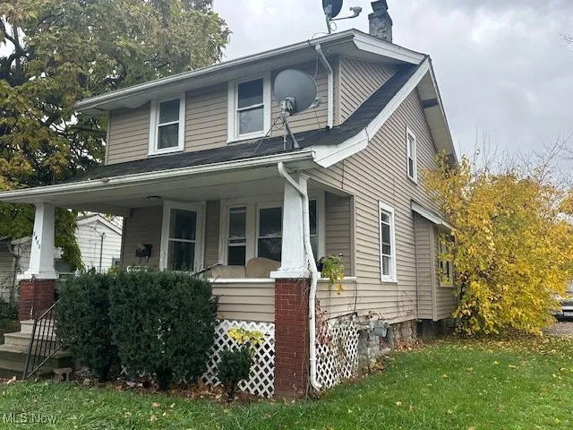 View of front of home with covered porch and a front yard