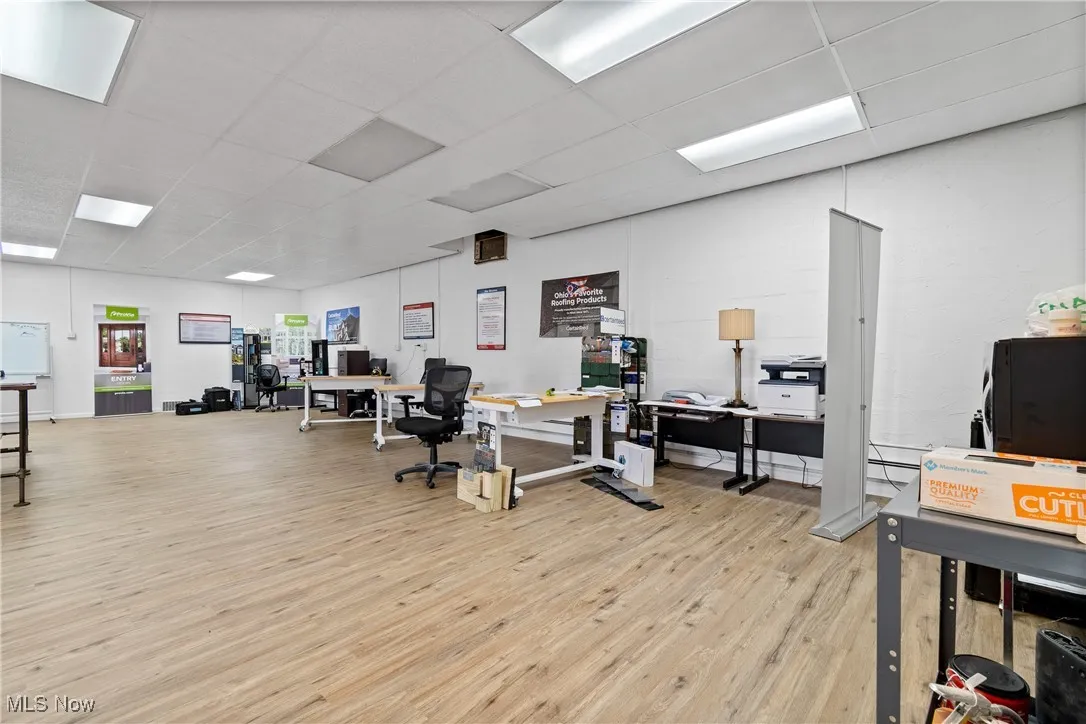 Office space with a paneled ceiling and light hardwood / wood-style flooring