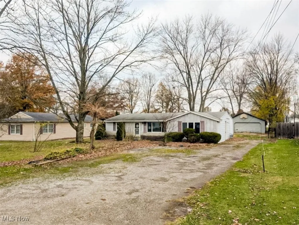 Ranch-style house featuring a garage and a front lawn