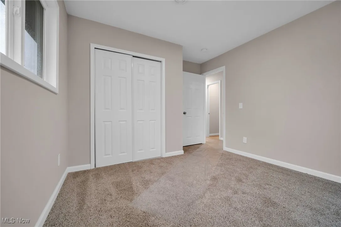 Unfurnished bedroom featuring carpet flooring and a closet
