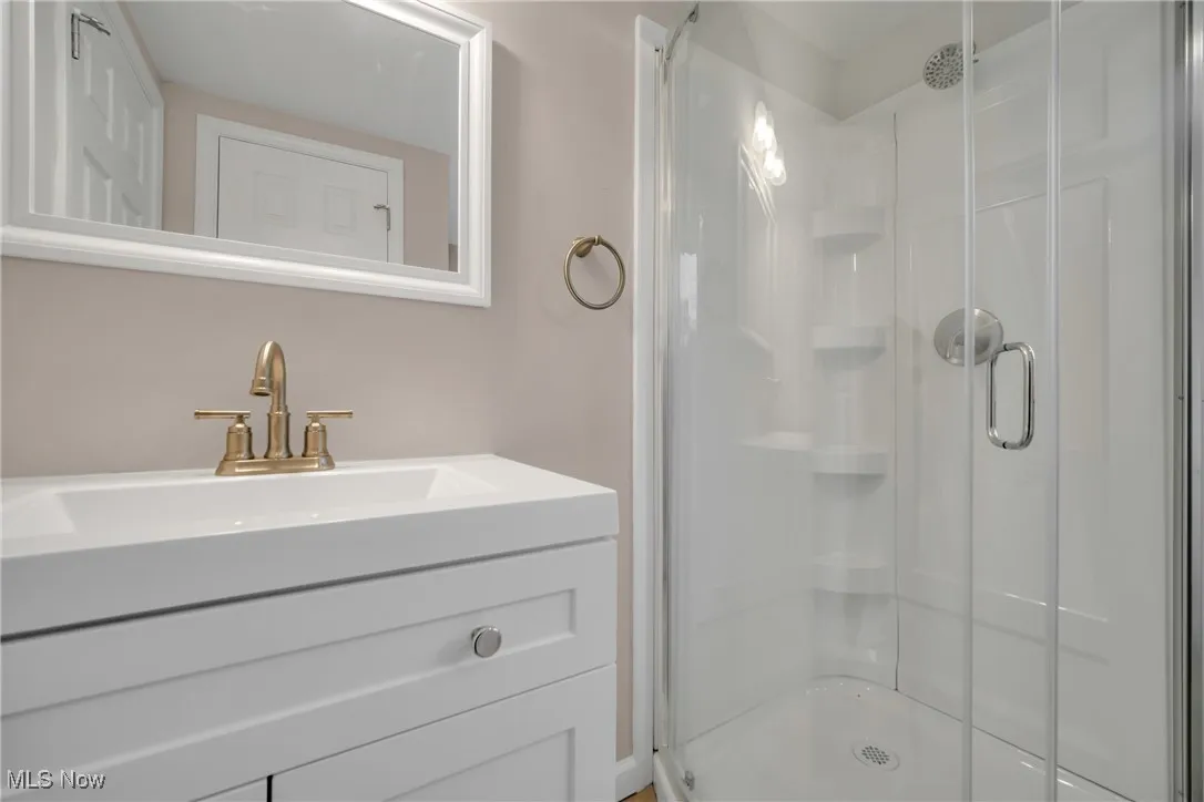 Bathroom featuring vanity and an enclosed shower
