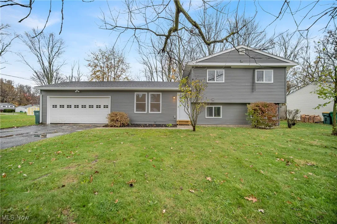 Split level home featuring a front yard and a garage