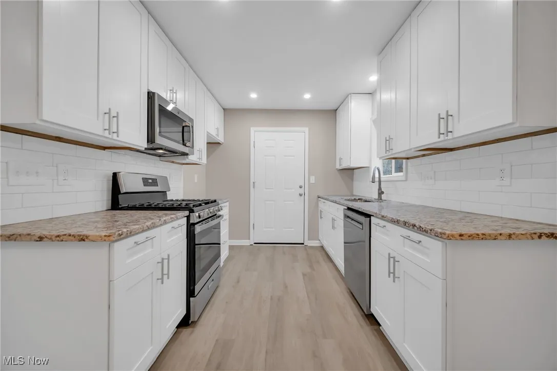Kitchen featuring white cabinetry and stainless steel appliances