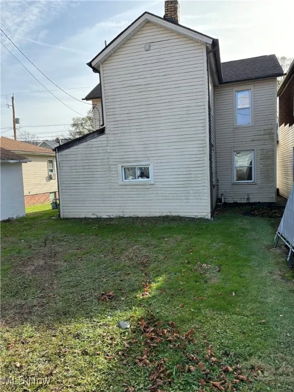 Rear view of house featuring a yard