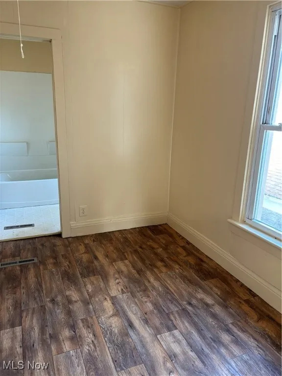 Unfurnished room with dark hardwood / wood-style floors