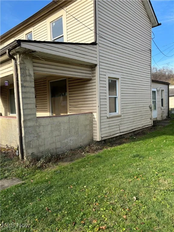 View of side of home with a yard
