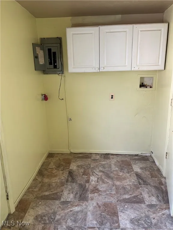 Laundry room with electric panel, cabinets, and washer hookup