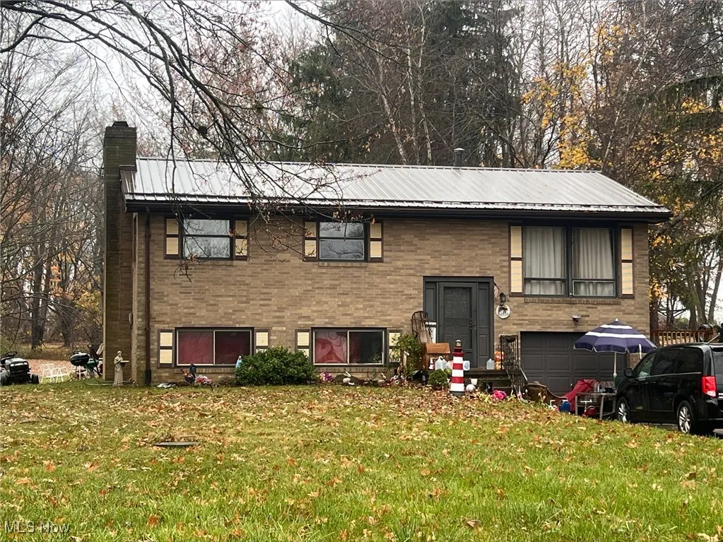 Bi-level home with a front yard and a garage