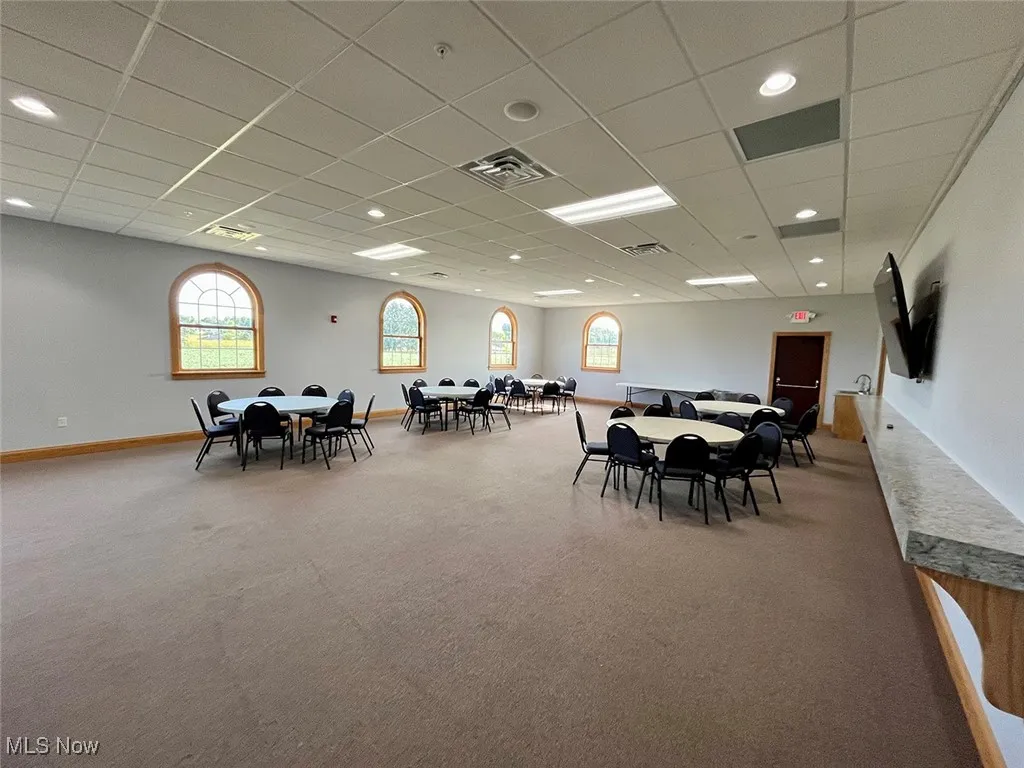 Dining area with carpet flooring and a paneled ceiling