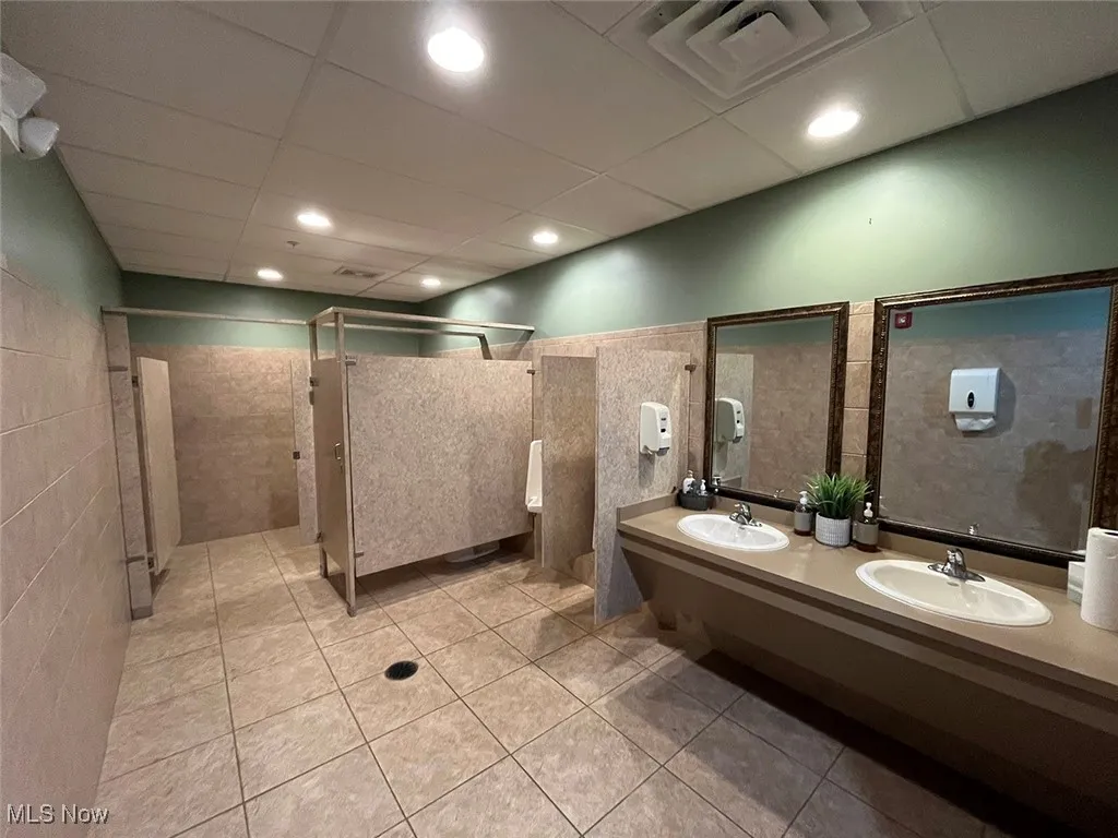 Bathroom featuring tile patterned flooring, a drop ceiling, tile walls, and vanity