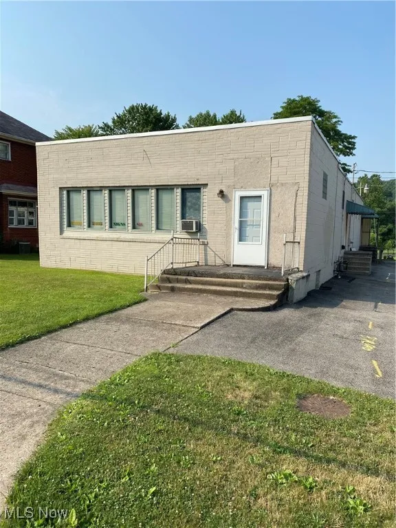 View of front of property featuring cooling unit and a front lawn