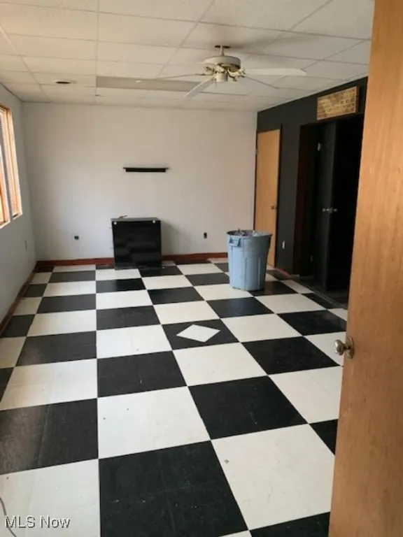 Spare room with a paneled ceiling and ceiling fan
