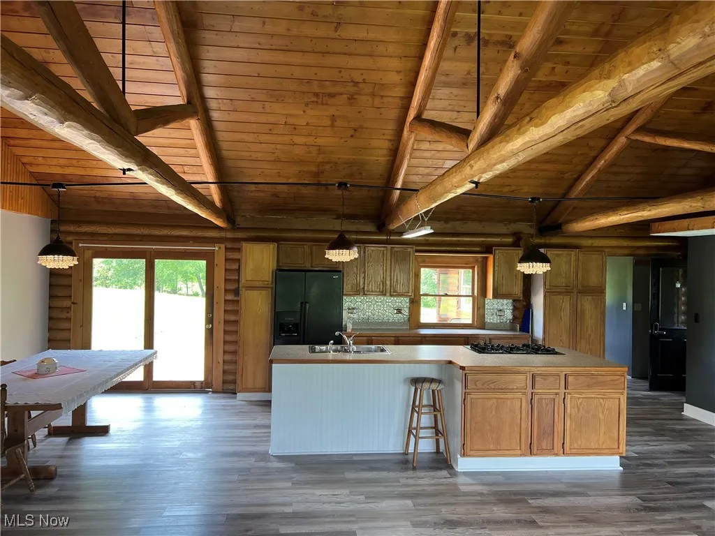 Kitchen featuring decorative light fixtures, black appliances, dark hardwood / wood-style floors, and wooden ceiling