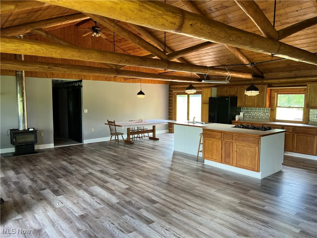 Kitchen featuring wood ceiling, pendant lighting, a center island, and black appliances