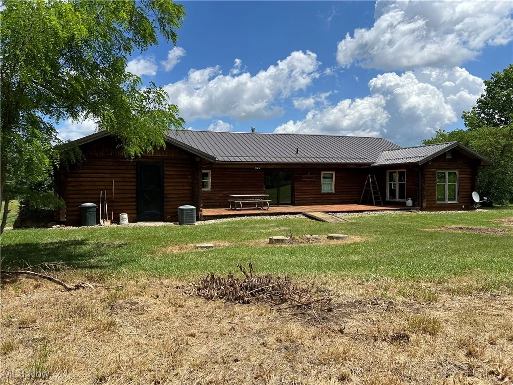 Rear view of house featuring a yard