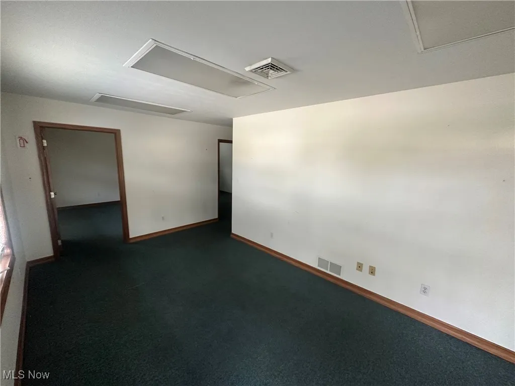 Unfurnished room with dark colored carpet