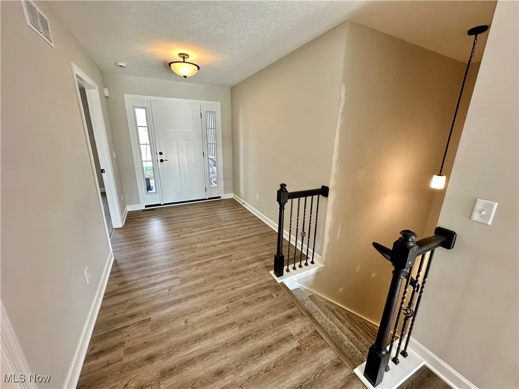 Entrance foyer featuring a textured ceiling and hardwood / wood-style flooring