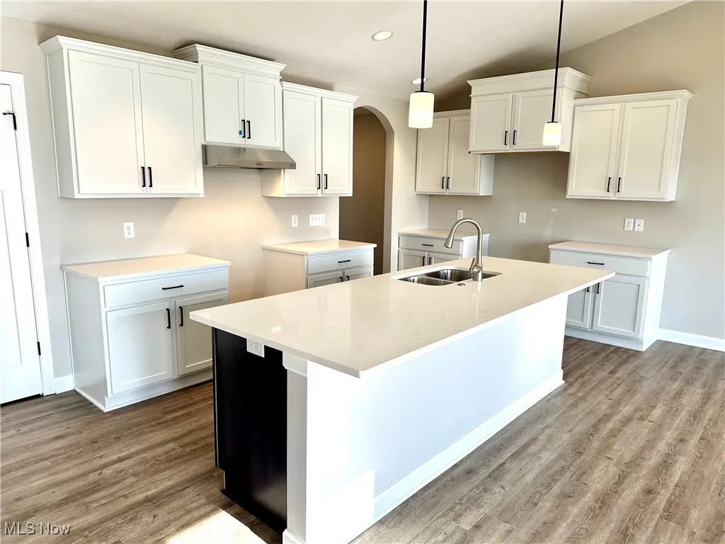 Kitchen featuring white cabinetry, sink, and pendant lighting