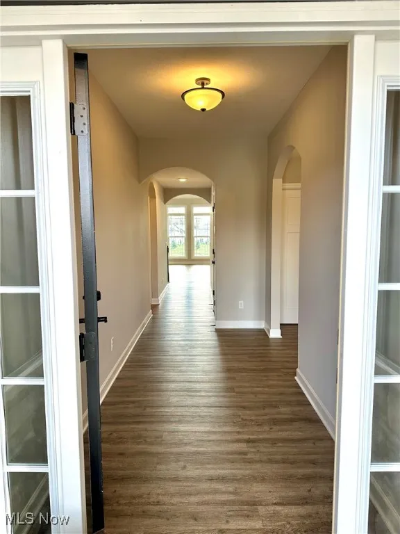 Hall with dark hardwood / wood-style flooring