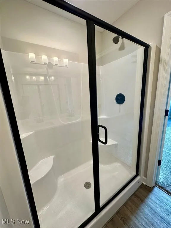Bathroom with hardwood / wood-style floors and walk in shower