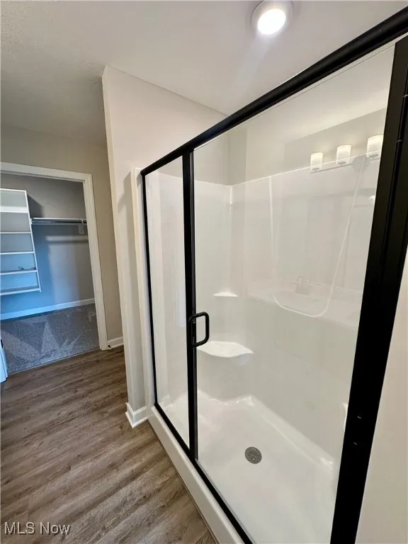 Bathroom featuring hardwood / wood-style flooring and a shower with door