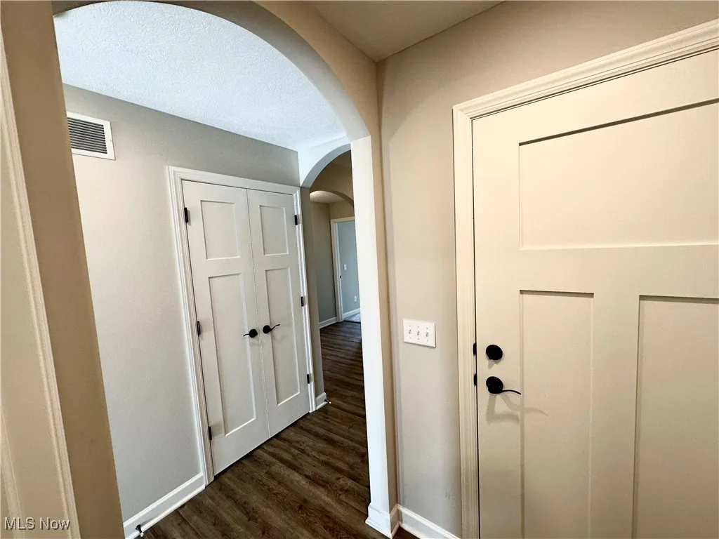 Hallway with dark wood-type flooring