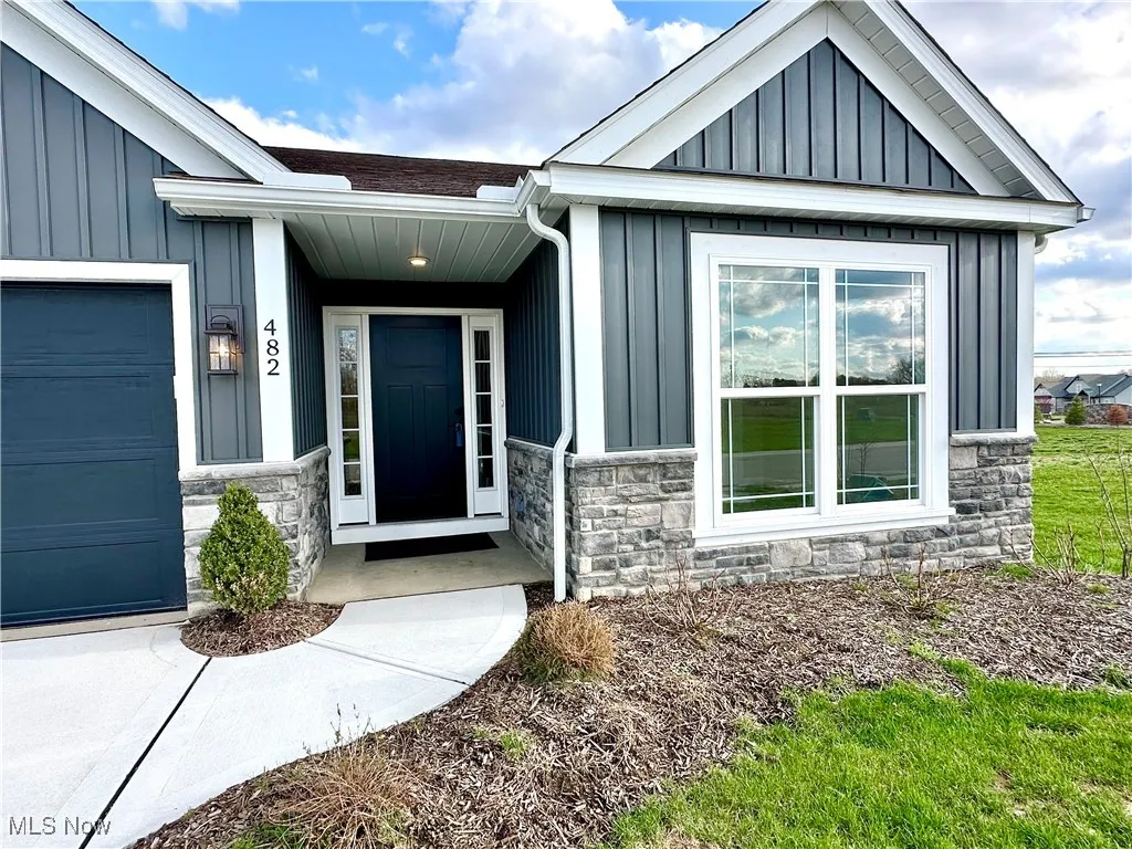 View of exterior entry with board and batten siding and stone siding