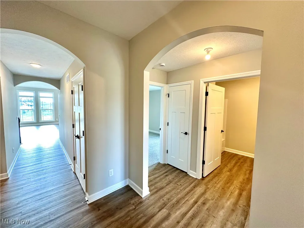 Hall featuring a textured ceiling and hardwood / wood-style flooring