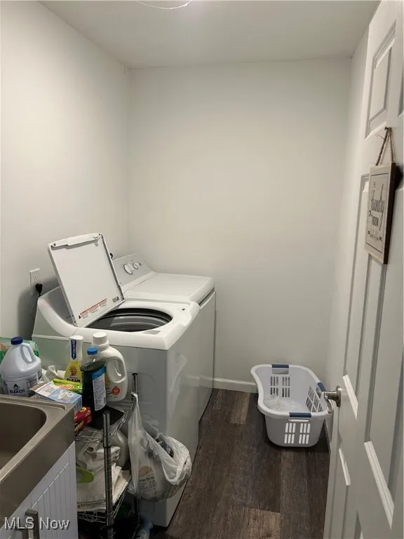 Laundry room featuring washer and dryer and dark wood-type flooring