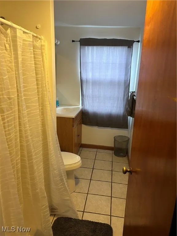 Bathroom featuring tile patterned flooring, vanity, and toilet