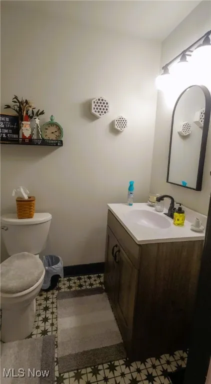 Spacious 1st floor half Bathroom with tile patterned flooring, vanity, and toilet