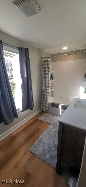 Spacious upstairs full Bathroom featuring vanity, shower / bathtub combination with curtain, corner closet, and laminate flooring.