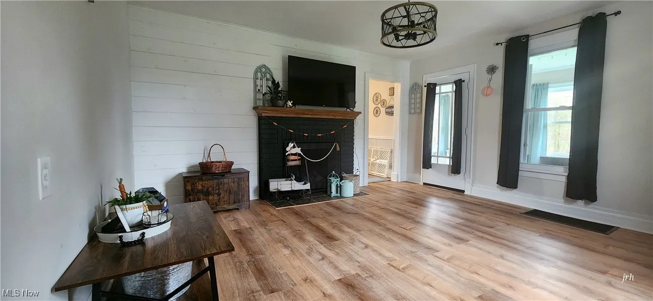 Living room featuring a fireplace, wood finished floors, and baseboards