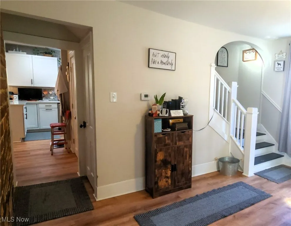 Stairs featuring wood-style flooring, easy flow to the upstairs.