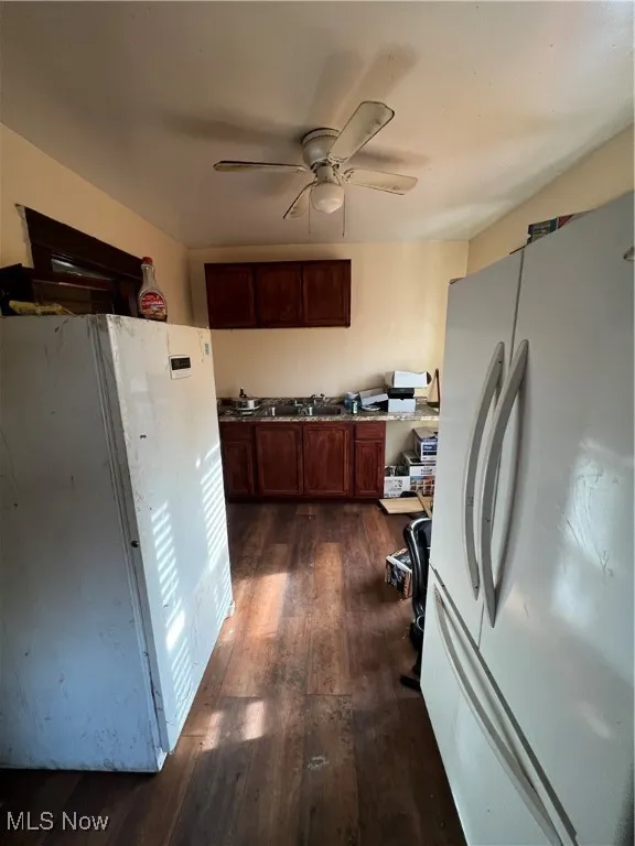 Kitchen featuring refrigerator, dark hardwood / wood-style floors, and ceiling fan