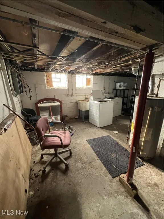 Basement featuring independent washer and dryer, sink, and water heater