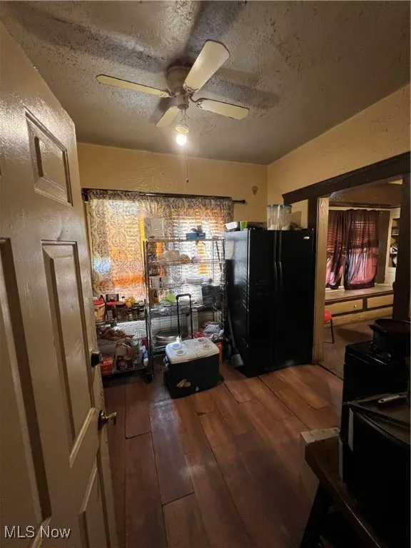 Kitchen featuring hardwood / wood-style flooring, ceiling fan, refrigerator, and a textured ceiling