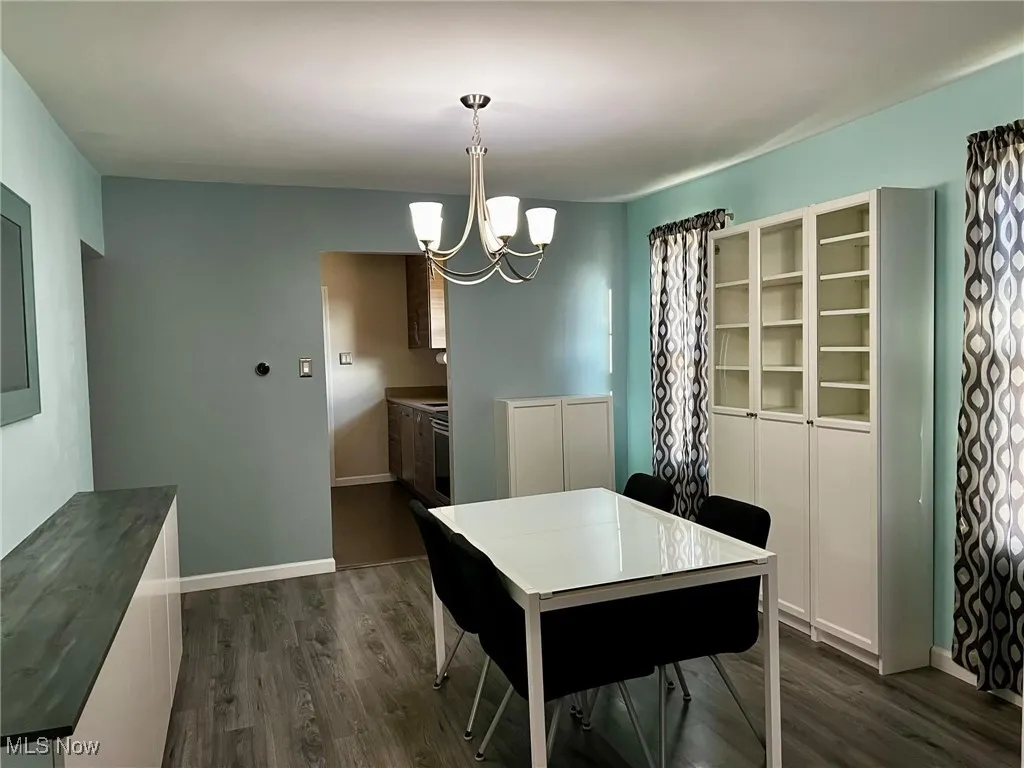 Dining room featuring a notable chandelier and dark hardwood / wood-style flooring
