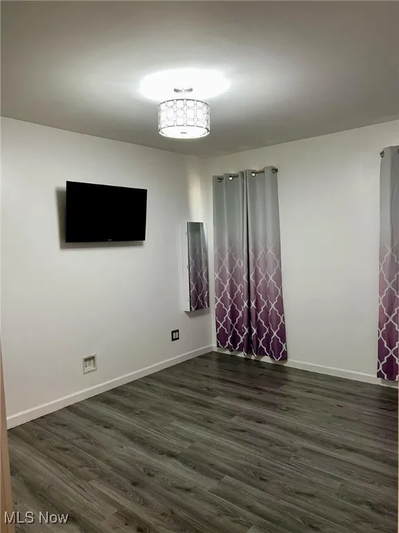 Empty room featuring dark wood-type flooring