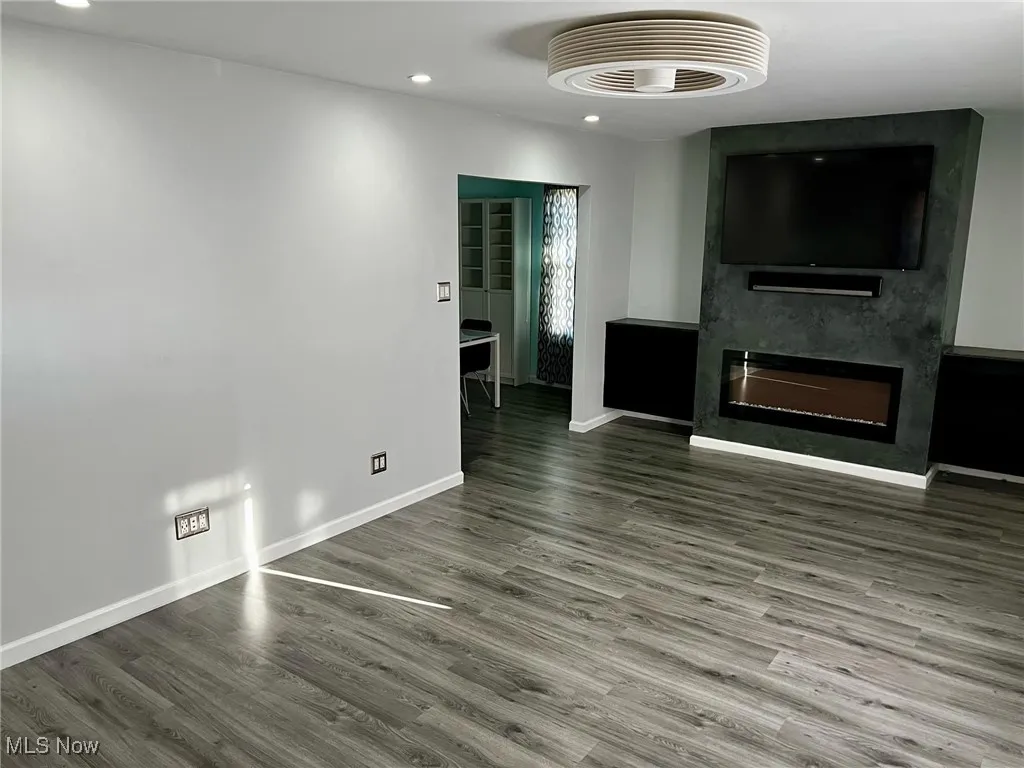 Unfurnished living room with hardwood / wood-style floors and a large fireplace