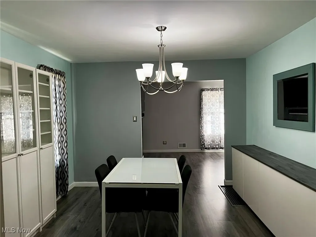 Dining room featuring dark hardwood / wood-style flooring and a chandelier