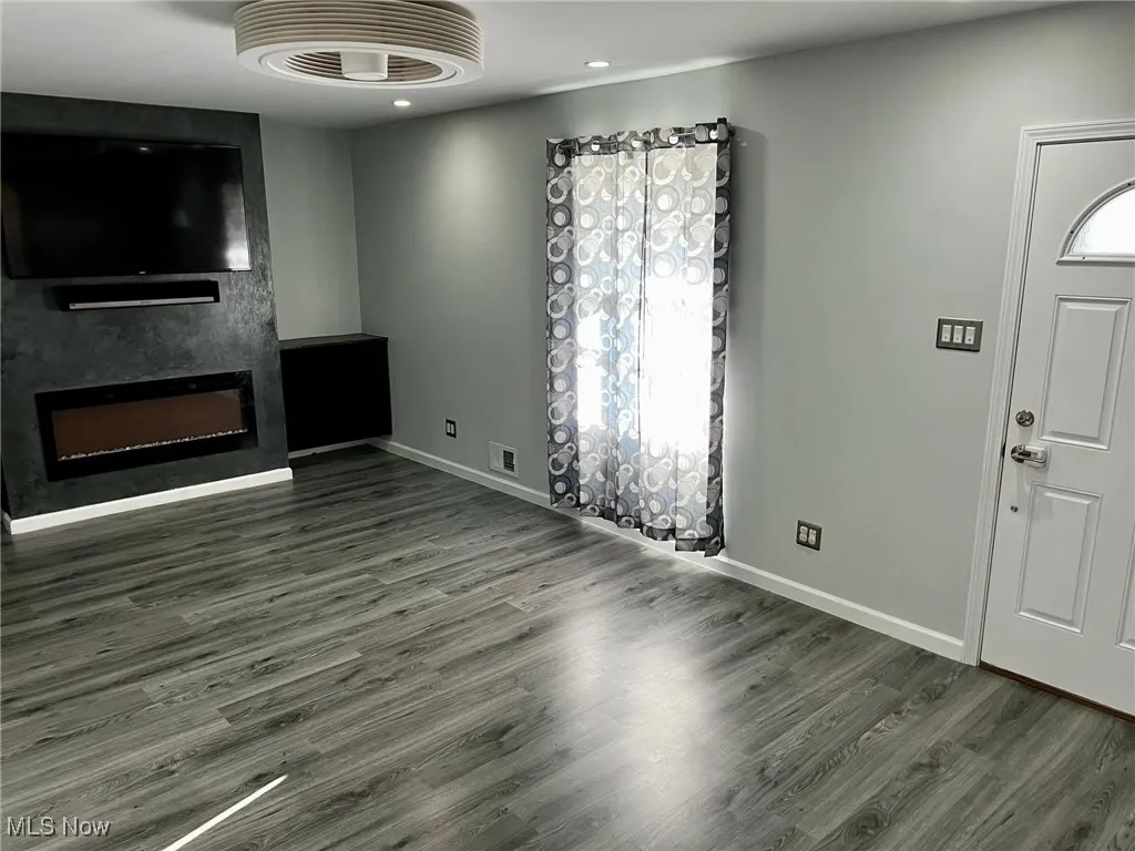 Unfurnished living room featuring dark hardwood / wood-style floors and a fireplace